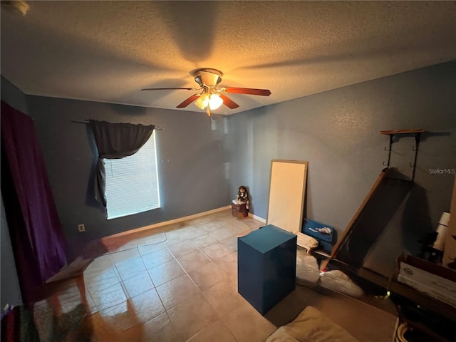 bedroom with baseboards, a textured ceiling, and a ceiling fan