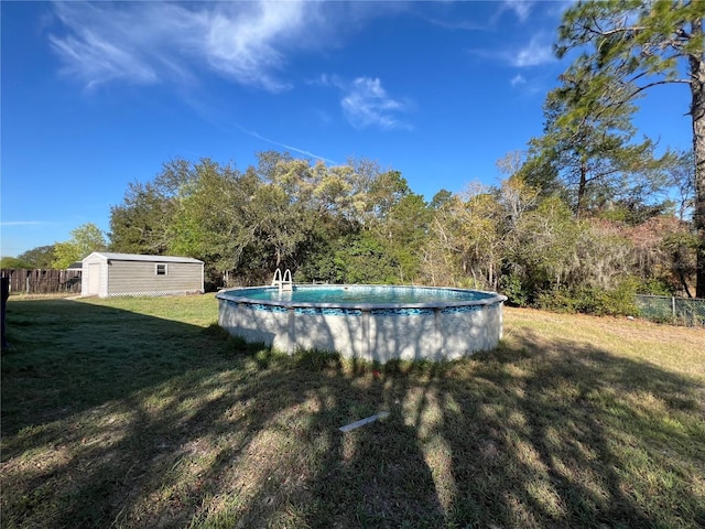 outdoor pool featuring a storage shed, an outbuilding, a yard, and fence