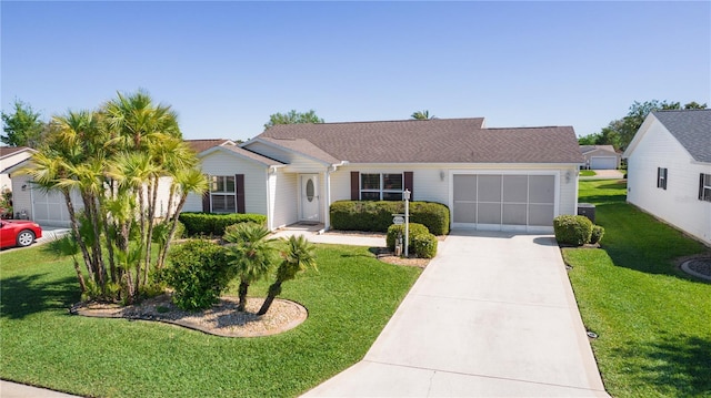 ranch-style home featuring concrete driveway, an attached garage, and a front yard