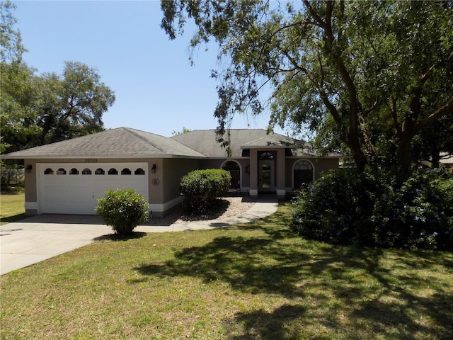 single story home with stucco siding, a front lawn, concrete driveway, and a garage