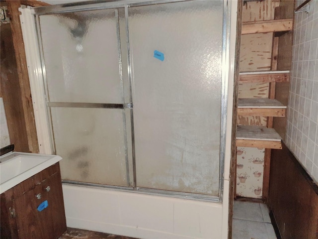 full bath featuring combined bath / shower with glass door, vanity, and tile patterned flooring