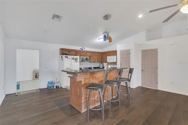 kitchen with white appliances, visible vents, lofted ceiling, ceiling fan, and dark countertops