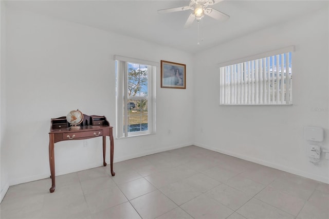 unfurnished room with light tile patterned floors, baseboards, a healthy amount of sunlight, and a ceiling fan