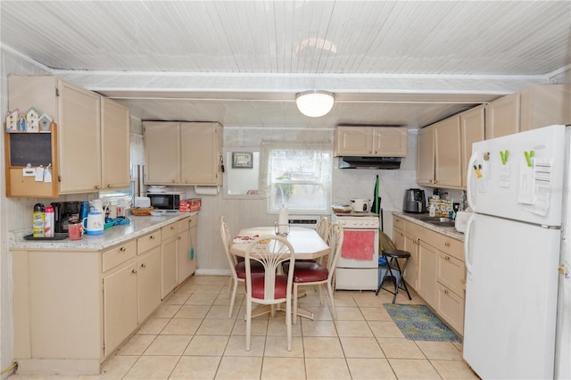 kitchen featuring light tile patterned floors, cream cabinets, white appliances, under cabinet range hood, and light countertops