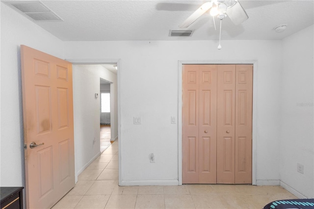 unfurnished bedroom with a closet, light tile patterned floors, visible vents, and baseboards
