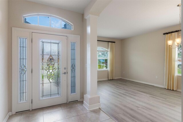 3341 Winchester Estates Cir, Lakeland, FL 33810 - entryway with ornate columns, a chandelier, baseboards, and light wood-style flooring