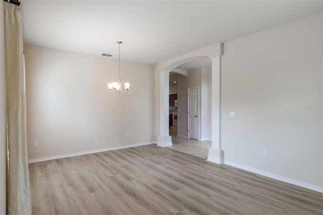 3341 Winchester Estates Cir, Lakeland, FL 33810 - spare room with light wood-style flooring, arched walkways, a chandelier, and baseboards