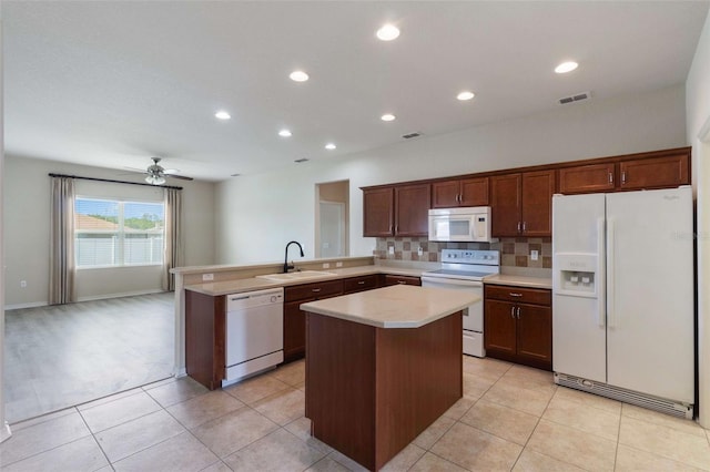 3341 Winchester Estates Cir, Lakeland, FL 33810 - kitchen with white appliances, a sink, a peninsula, light countertops, and a center island
