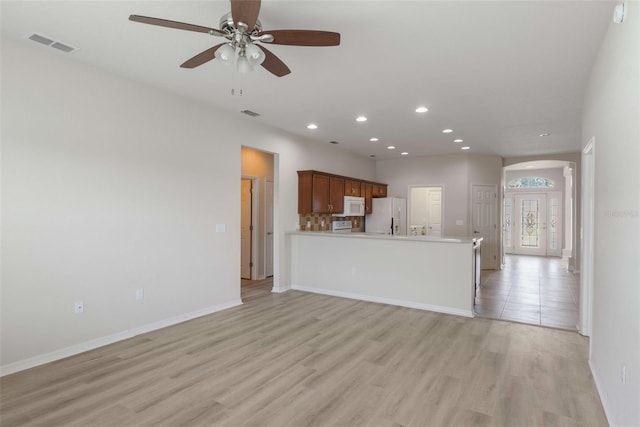 3341 Winchester Estates Cir, Lakeland, FL 33810 - unfurnished living room with light wood-type flooring, recessed lighting, a ceiling fan, baseboards, and arched walkways