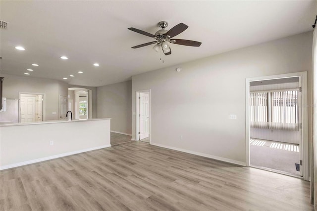 3341 Winchester Estates Cir, Lakeland, FL 33810 - unfurnished living room with recessed lighting, light wood-style flooring, a ceiling fan, baseboards, and arched walkways