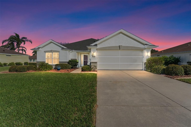 single story home featuring stucco siding, driveway, an attached garage, and a front yard