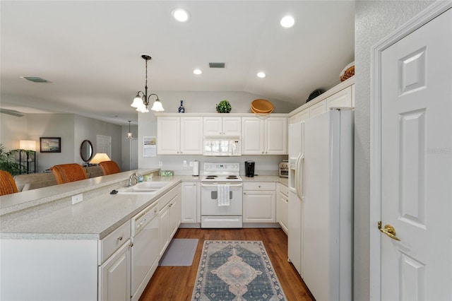 kitchen featuring white appliances, visible vents, a peninsula, a sink, and dark wood-type flooring