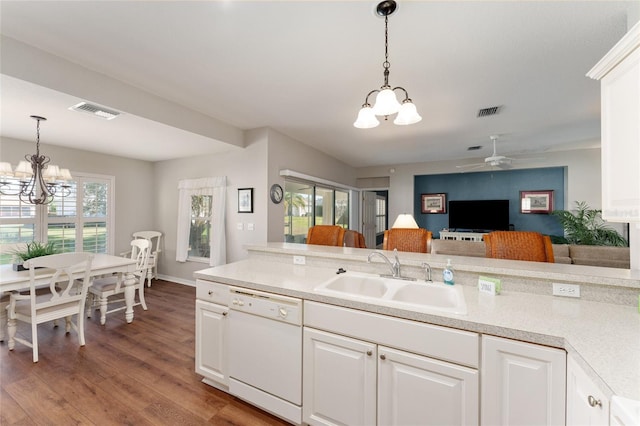 kitchen with wood finished floors, visible vents, white dishwasher, a sink, and light countertops