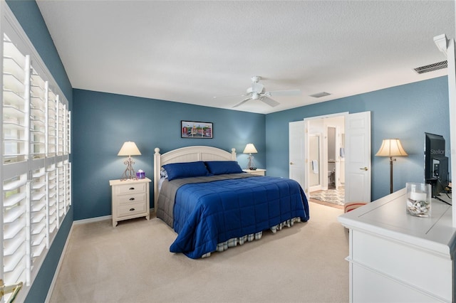bedroom featuring light carpet, visible vents, and a textured ceiling