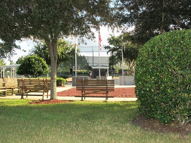 view of property's community featuring a yard and fence