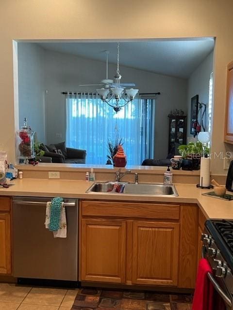 kitchen with lofted ceiling, light countertops, a sink, and appliances with stainless steel finishes