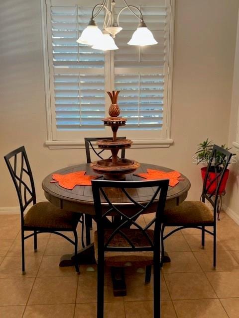 dining space with baseboards and light tile patterned floors