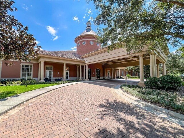 view of building exterior featuring a carport and decorative driveway