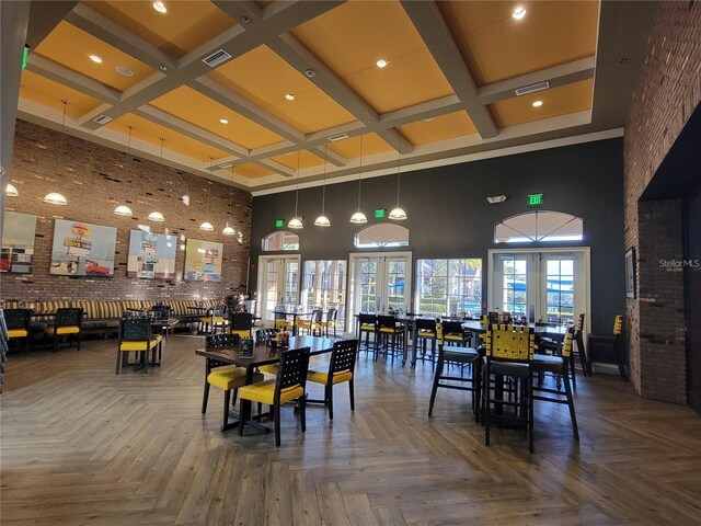 dining room featuring visible vents, a towering ceiling, and coffered ceiling