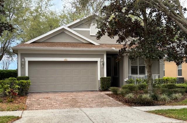 view of front of house with stucco siding, an attached garage, decorative driveway, and covered porch