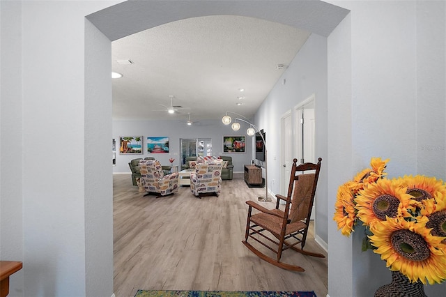 living room with baseboards, wood finished floors, and a textured ceiling