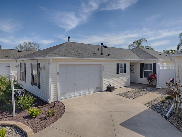 1829 Foxwood Ln, The Villages, FL 32162 - view of front of house with roof with shingles, concrete driveway, an attached garage, and fence
