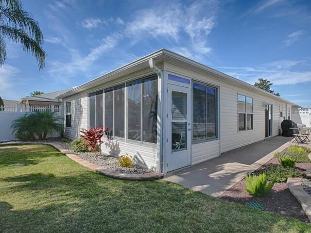 1829 Foxwood Ln, The Villages, FL 32162 - view of home's exterior featuring a yard, a sunroom, a patio area, and fence