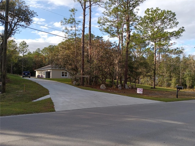 view of front of house with concrete driveway and a front lawn