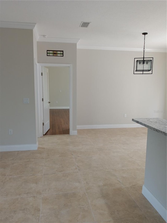 unfurnished room with visible vents, baseboards, and ornamental molding