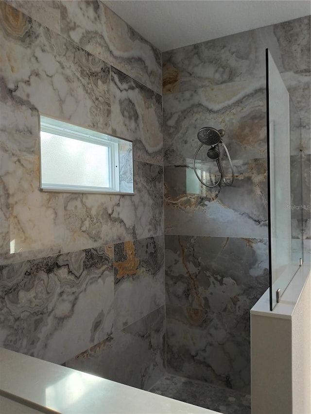 full bathroom with a marble finish shower