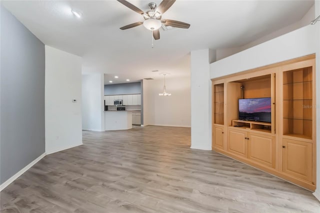 6200 Topsail Rd, Lady Lake, FL 32159 - unfurnished living room featuring recessed lighting, ceiling fan with notable chandelier, light wood-type flooring, and baseboards