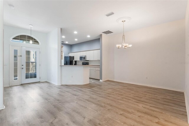 6200 Topsail Rd, Lady Lake, FL 32159 - unfurnished living room featuring baseboards, visible vents, light wood finished floors, recessed lighting, and a chandelier