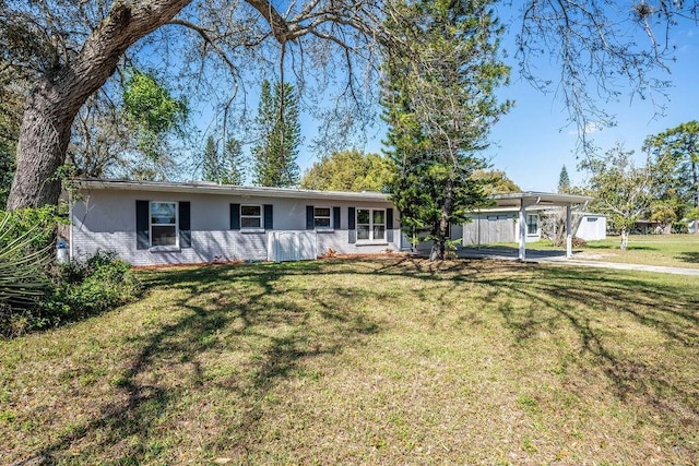 ranch-style house featuring a carport, brick siding, stucco siding, and a front lawn