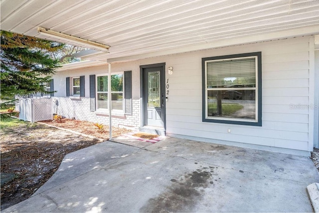 view of exterior entry featuring brick siding