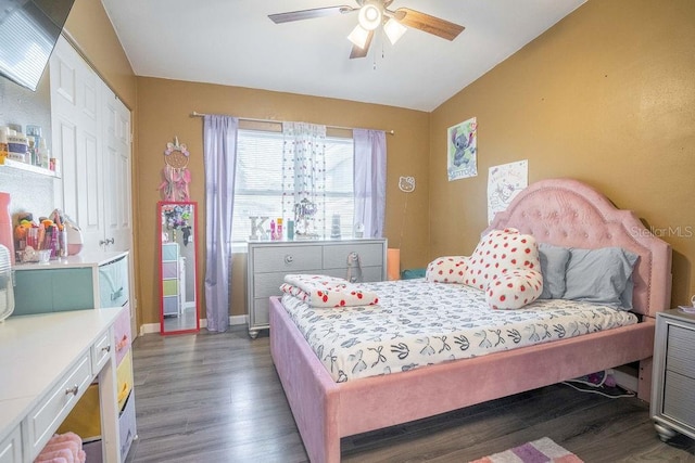 bedroom with a closet, baseboards, wood finished floors, lofted ceiling, and ceiling fan