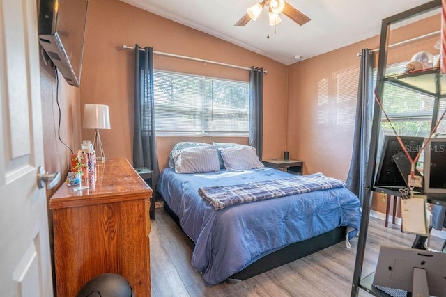 bedroom featuring wood finished floors and lofted ceiling