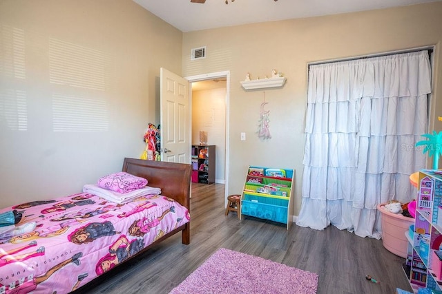 bedroom featuring visible vents, baseboards, vaulted ceiling, and wood finished floors