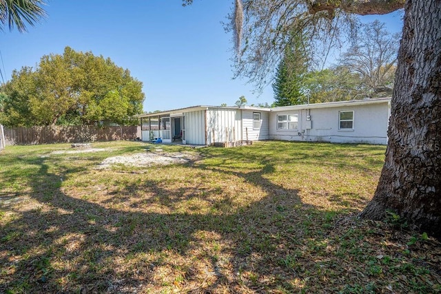 back of property featuring a yard and fence