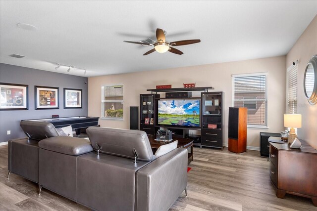 living room with wood finished floors, ceiling fan, and baseboards