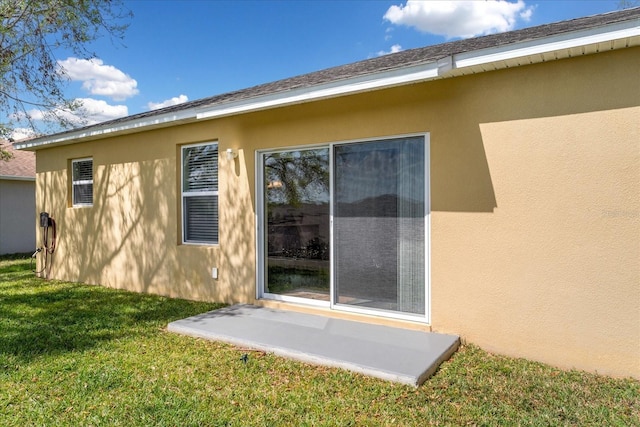 exterior space with a yard and stucco siding