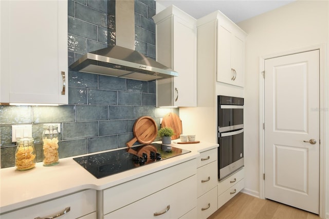 981 Fiesta Key Cir, Lady Lake, FL 32159 - kitchen with decorative backsplash, black appliances, wall chimney range hood, and white cabinets