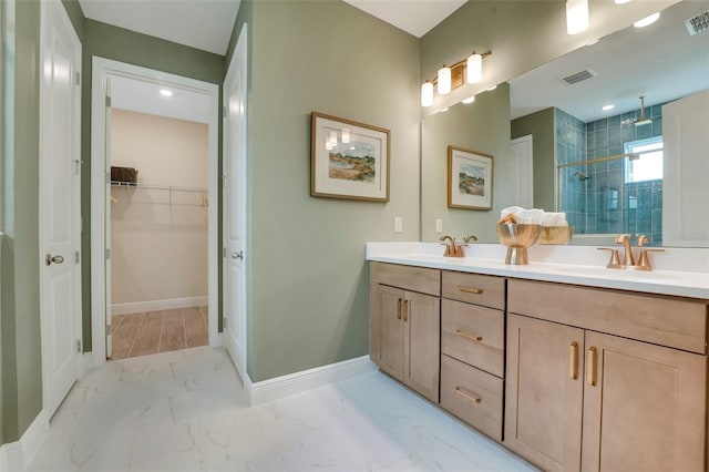 981 Fiesta Key Cir, Lady Lake, FL 32159 - bathroom featuring double vanity, a stall shower, a spacious closet, marble look tile flooring, and baseboards