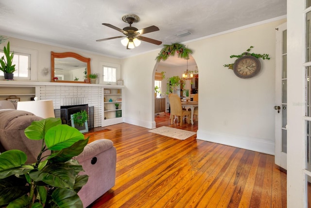 living room with arched walkways, baseboards, plenty of natural light, and hardwood / wood-style floors