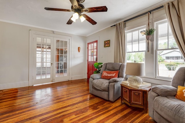sitting room featuring ceiling fan, wood-type flooring, french doors, baseboards, and ornamental molding
