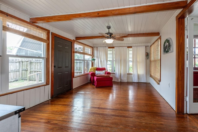 sunroom / solarium with a healthy amount of sunlight, radiator, beamed ceiling, and hardwood / wood-style floors