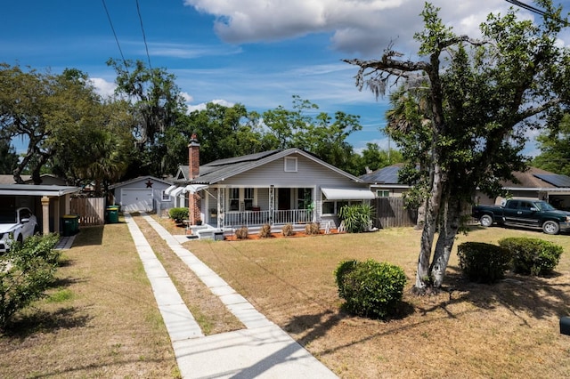 bungalow featuring a garage, a front lawn, fence, concrete driveway, and a porch