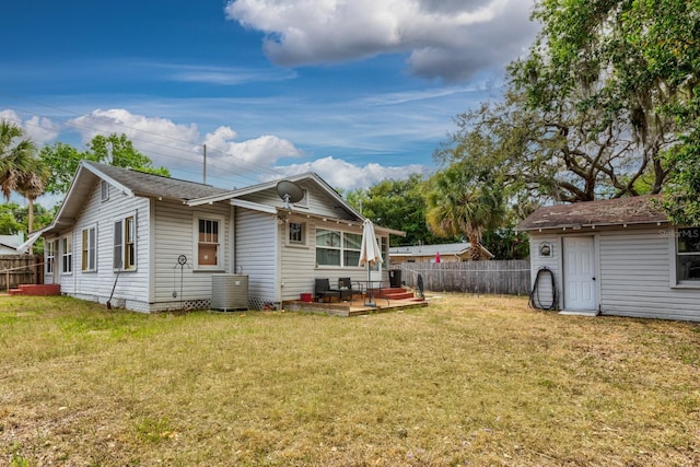 back of property with a fenced backyard, central AC, and a yard