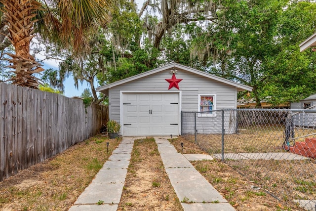 detached garage with fence and concrete driveway