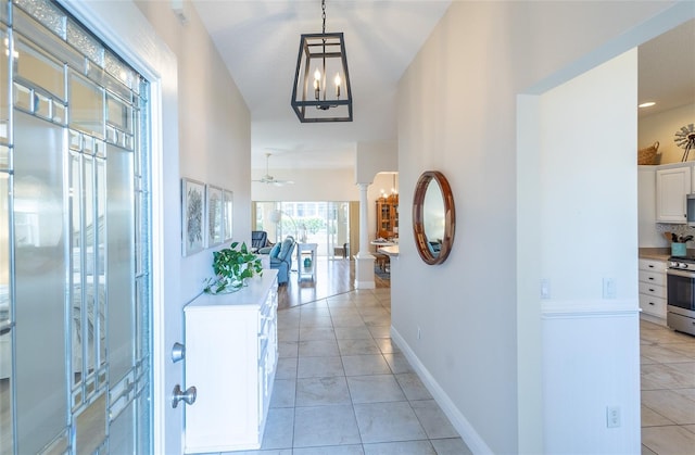 1046 Ridgeland Path, The Villages, FL 32162 - corridor with baseboards, a notable chandelier, and light tile patterned floors