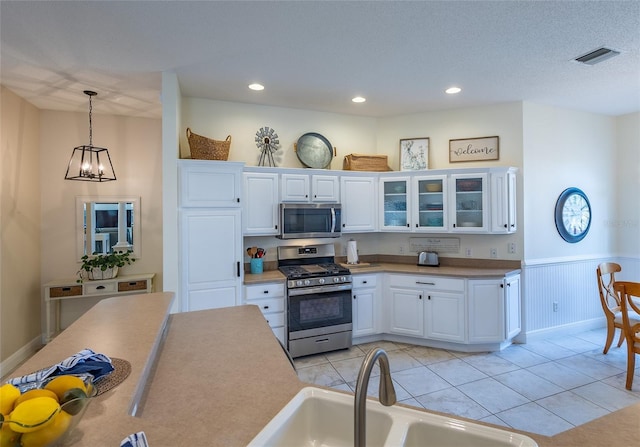 1046 Ridgeland Path, The Villages, FL 32162 - kitchen featuring a sink, pendant lighting, appliances with stainless steel finishes, visible vents, and white cabinets